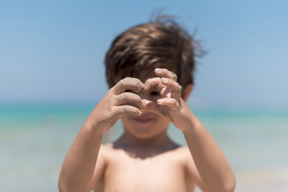 Close up kid hands playing beach